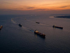 Aerial view of the Strait of Hormuz at dusk showing reduced commercial traffic amid the Iran 2026 war and the closure of the world's most critical oil transit chokepoint
