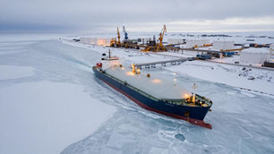 Drone photograph of Russian Arctic LNG terminal in winter showing tanker ship navigating through ice channel at Yamal Peninsula infrastructure