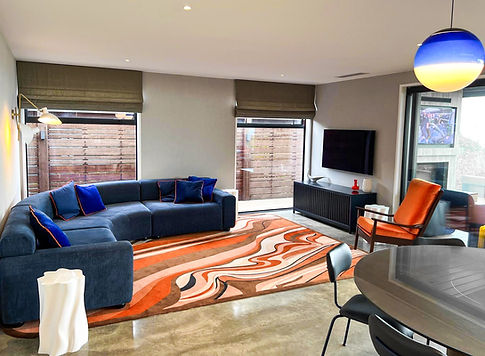The Kererū rug in vibrant orange in the living room of a home in Waikanae, New Zealand