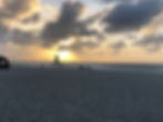 Eagle Beach at sunset with catamaran sailing