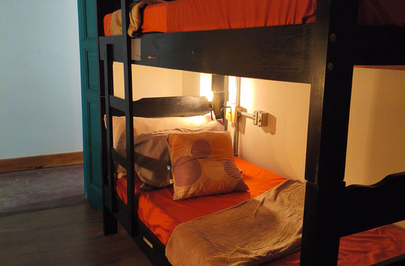 Beliches com luz quente em quarto compartilhado, com uma cadeira