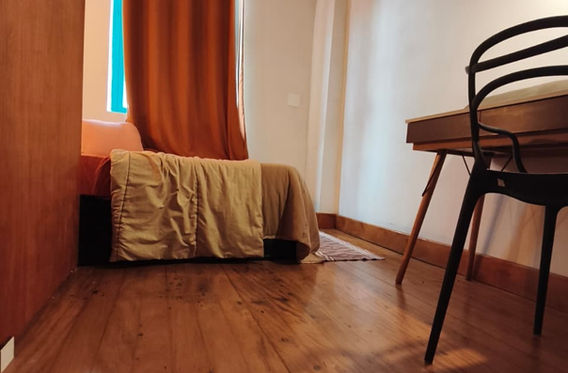 Quarto com cama, cadeira de escritório e cortinas