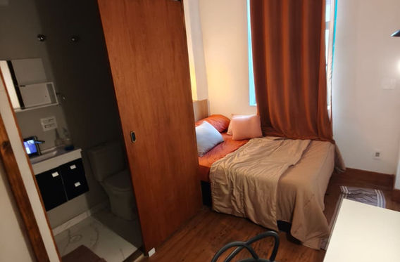 Quarto com cama, guarda-roupa e cadeira