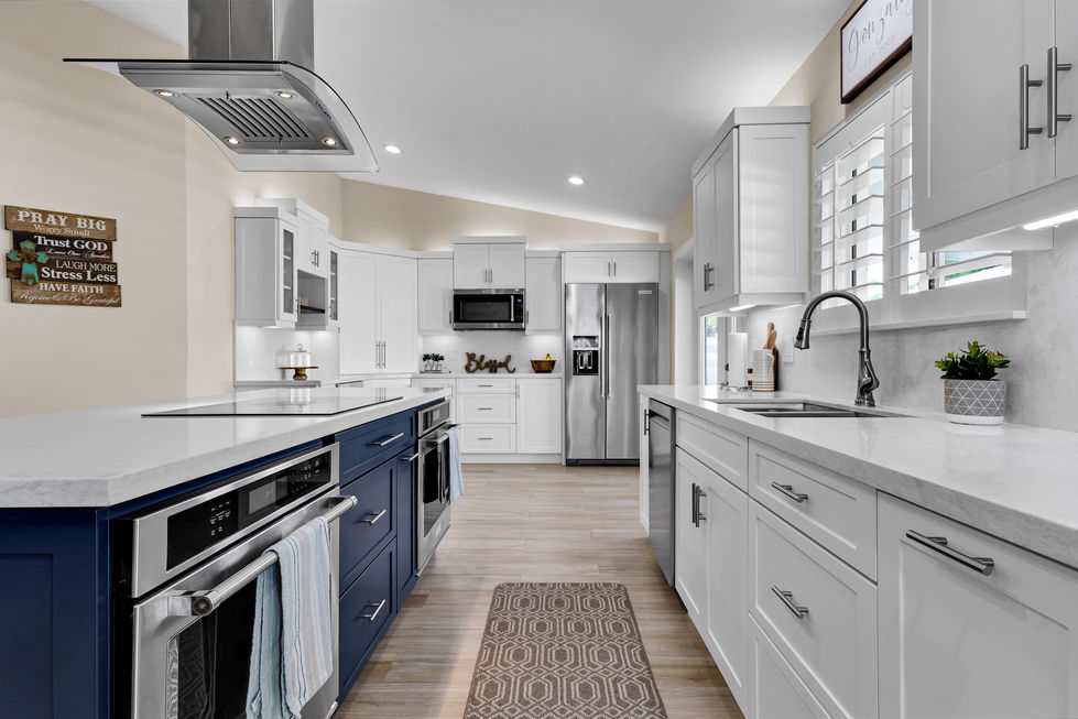 White kitchen with open-concept layout, blue island cabinets, recessed lighting, and wood plank floor tile in a Miami home