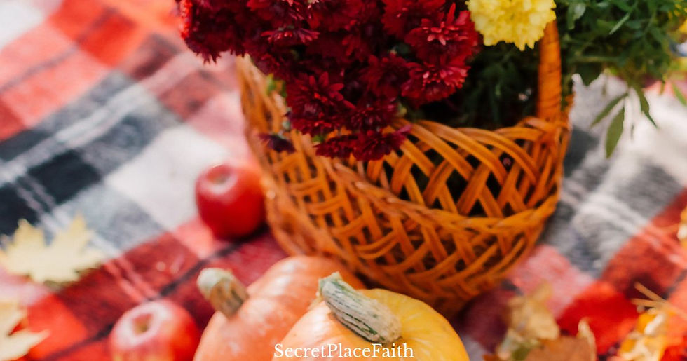 Autumn still life with a basket of flowers, pumpkins and apples on a plaid blanket; SecretPlaceFaith text visible.