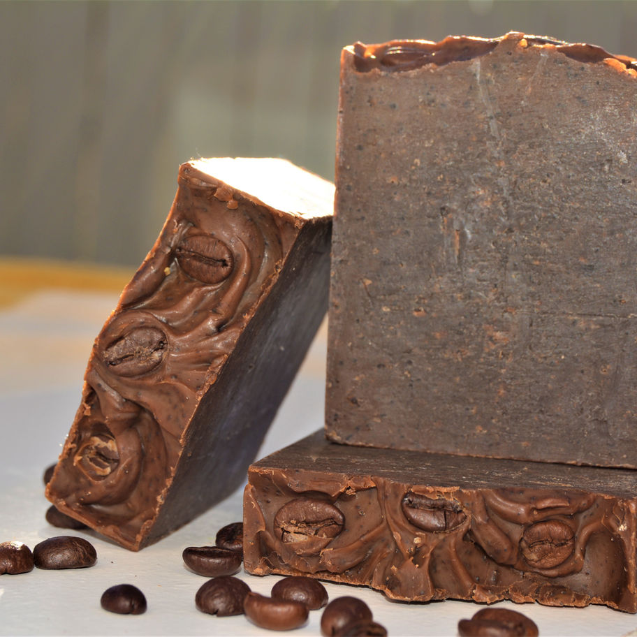 Three brown Wake Me Up Coffee - Bar Soaps with coffee beans; close-up photo.