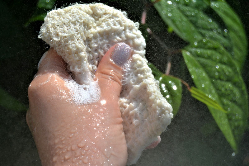 Hand squeezing soapy saver bag with bubbles and water