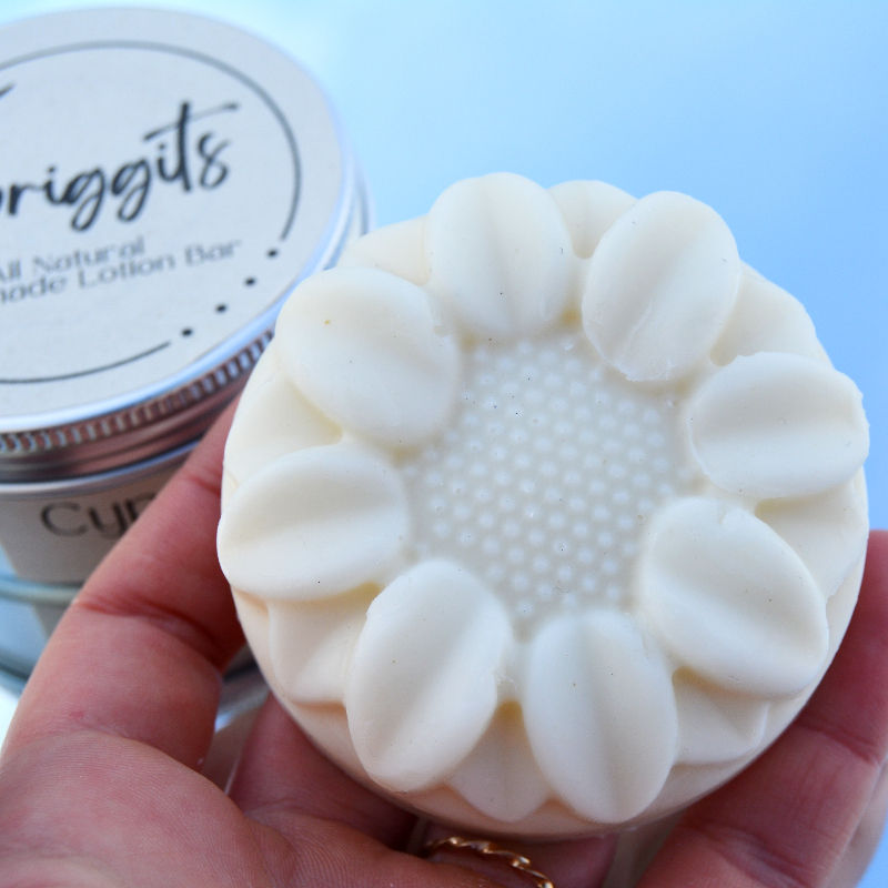 Hand holding a round white lotion bar