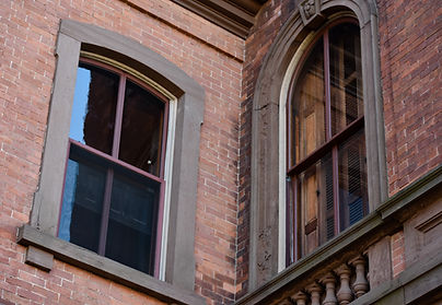 Two windows on the exterior of a brick building