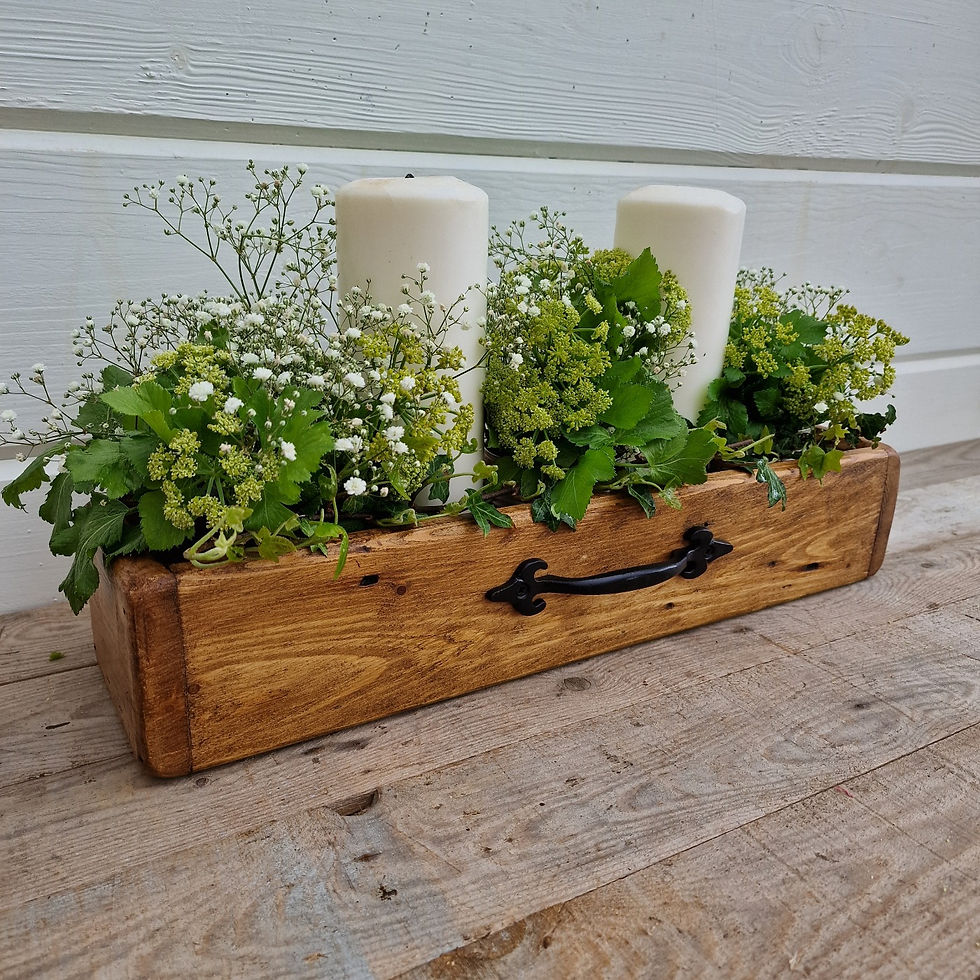 Thumbnail: pretty wooden table centrepiece display box pictured with two pillar candles and green and white foliage display