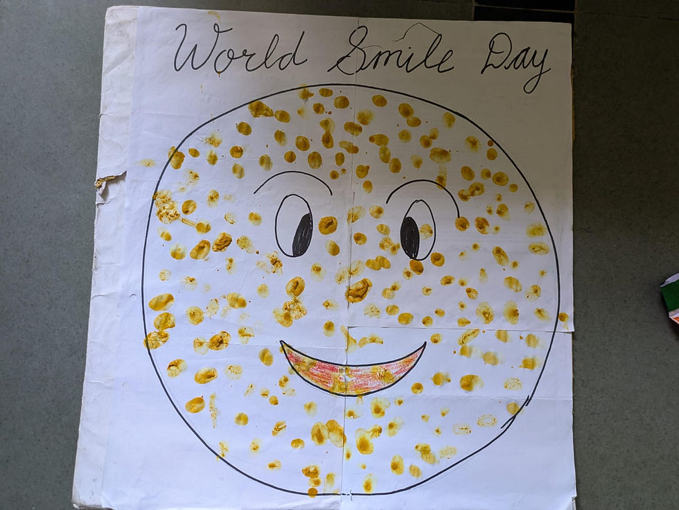 Handmade World Smile Day poster with a smiling yellow-dotted face and handwritten title on white paper.