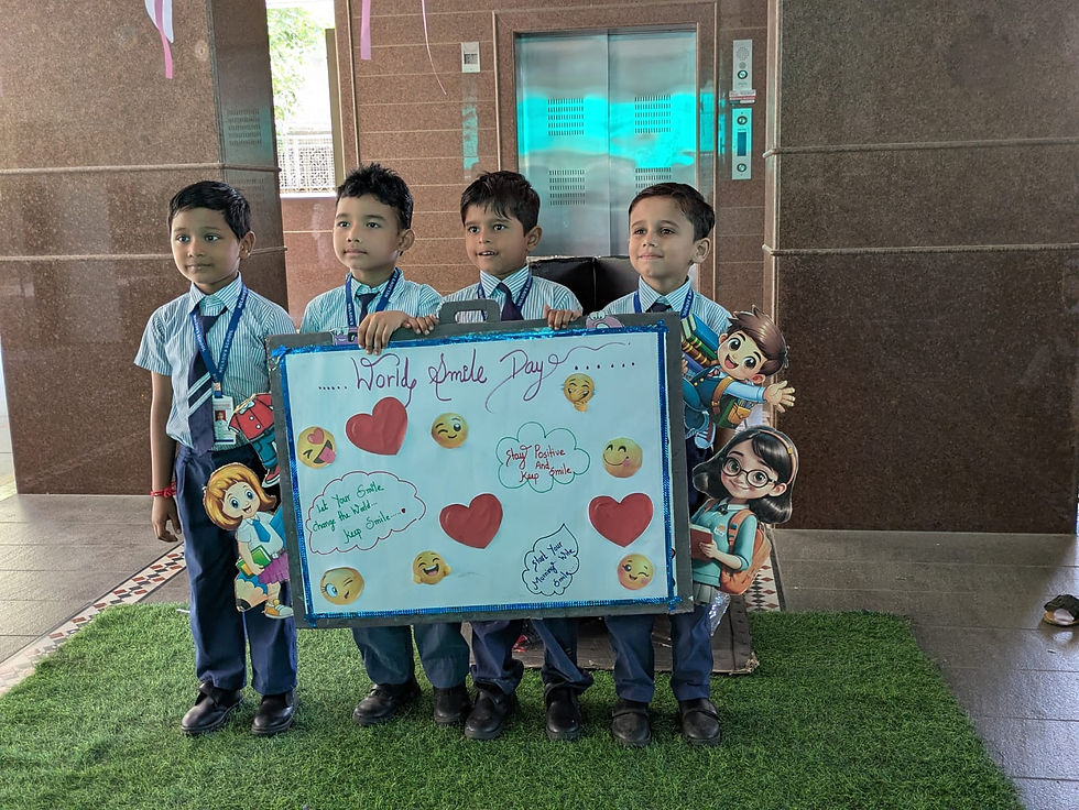 Four schoolboys in uniforms hold a World Smile Day poster with emojis and hearts in a lobby by an elevator.