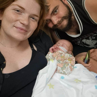 Mama and Dad cuddling baby in NICU