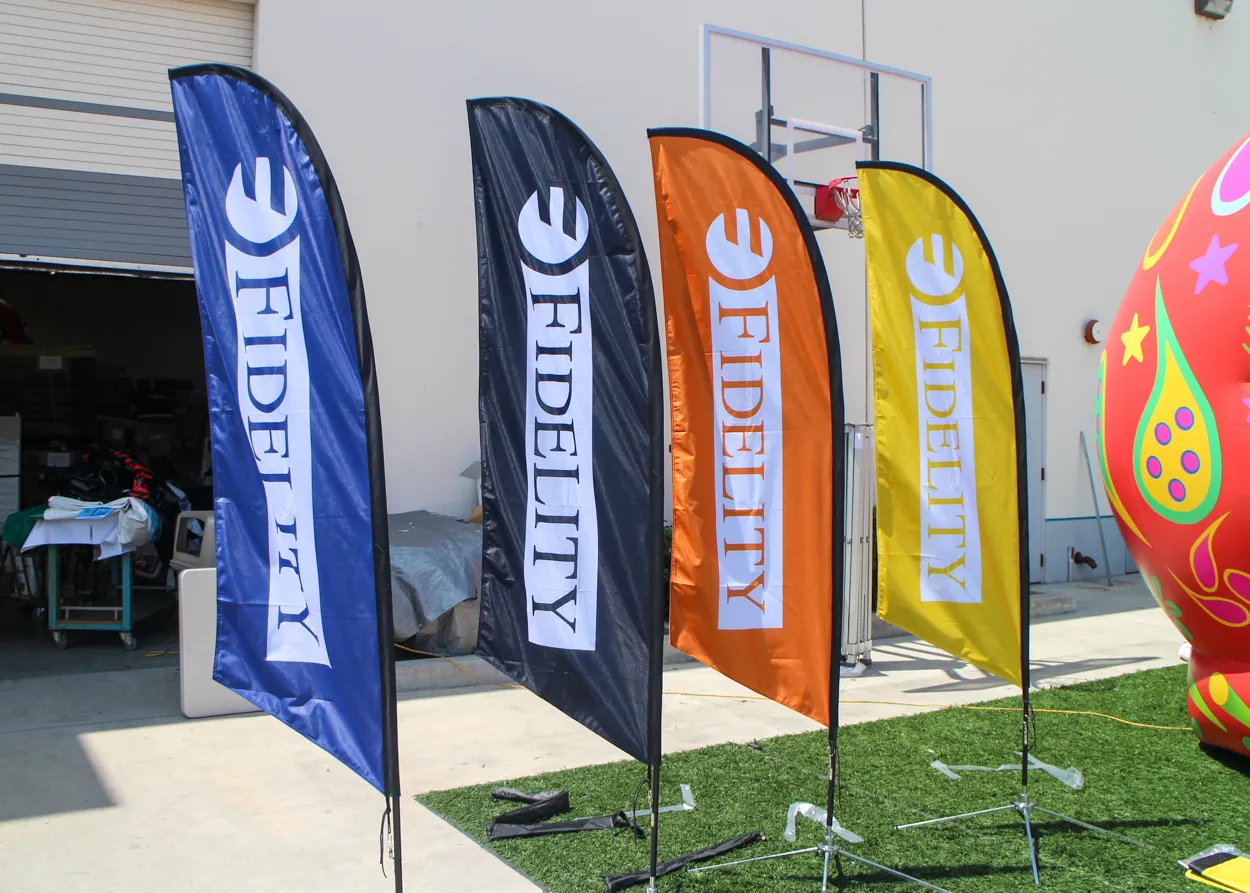 Fidelity custom feather flags in blue, black, orange, and yellow for canopy displays.
