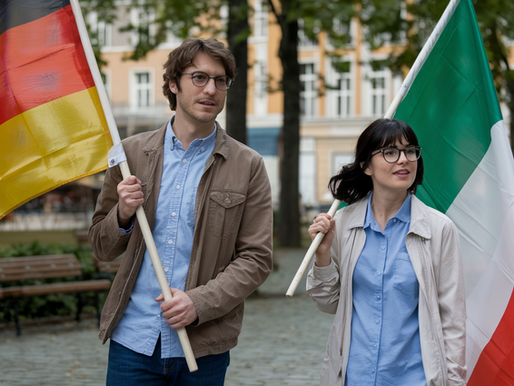 Homem segurando uma bandeira da Alemanhã, ao lado de uma mulher segurando uma bandeira da itália. O casal está caminhando em um parque europeu.