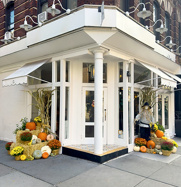 Autumn Charm Company fall porch decorating at a storefront.