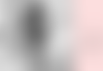 A lady sitting on a bed holding her hand over her mouth