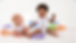 Two babies playing with colorful alphabet letters