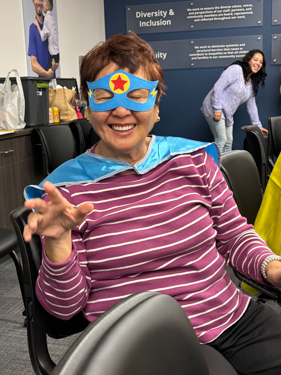 Woman in superhero mask, cape, smiling,