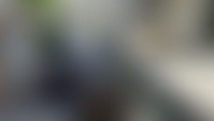 Partially rebuilt backyard fountain showing an open basin, stacked masonry blocks, temporary cover, and surrounding patio space, mid-construction with visible constraints and unfinished details.