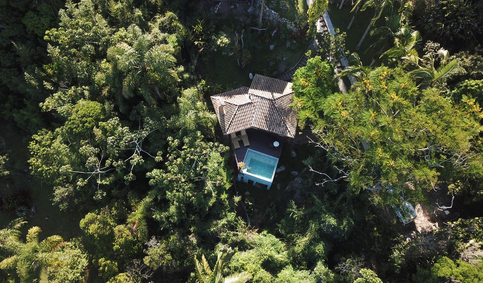 Vista Aérea de drone do Chalé Refúgio Imerso no Amplo Terreno de Mata Nativa da Pousada Caminho do Rei