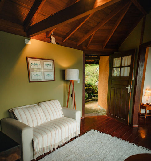 Interior charmoso e aconchegante da sala do Chalé Refúgio.