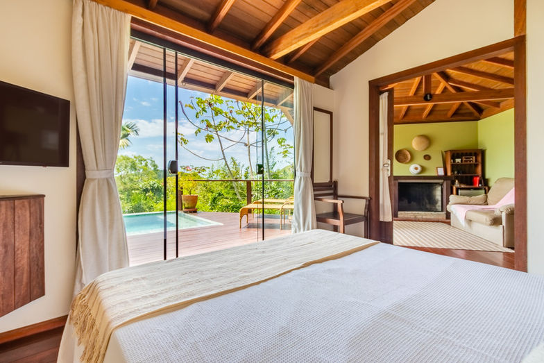 Vista Geral da Acomodação com Cama Queen, Piscina Privativa na Varanda e Sala de Estar com Lareira - Chalé Refúgio