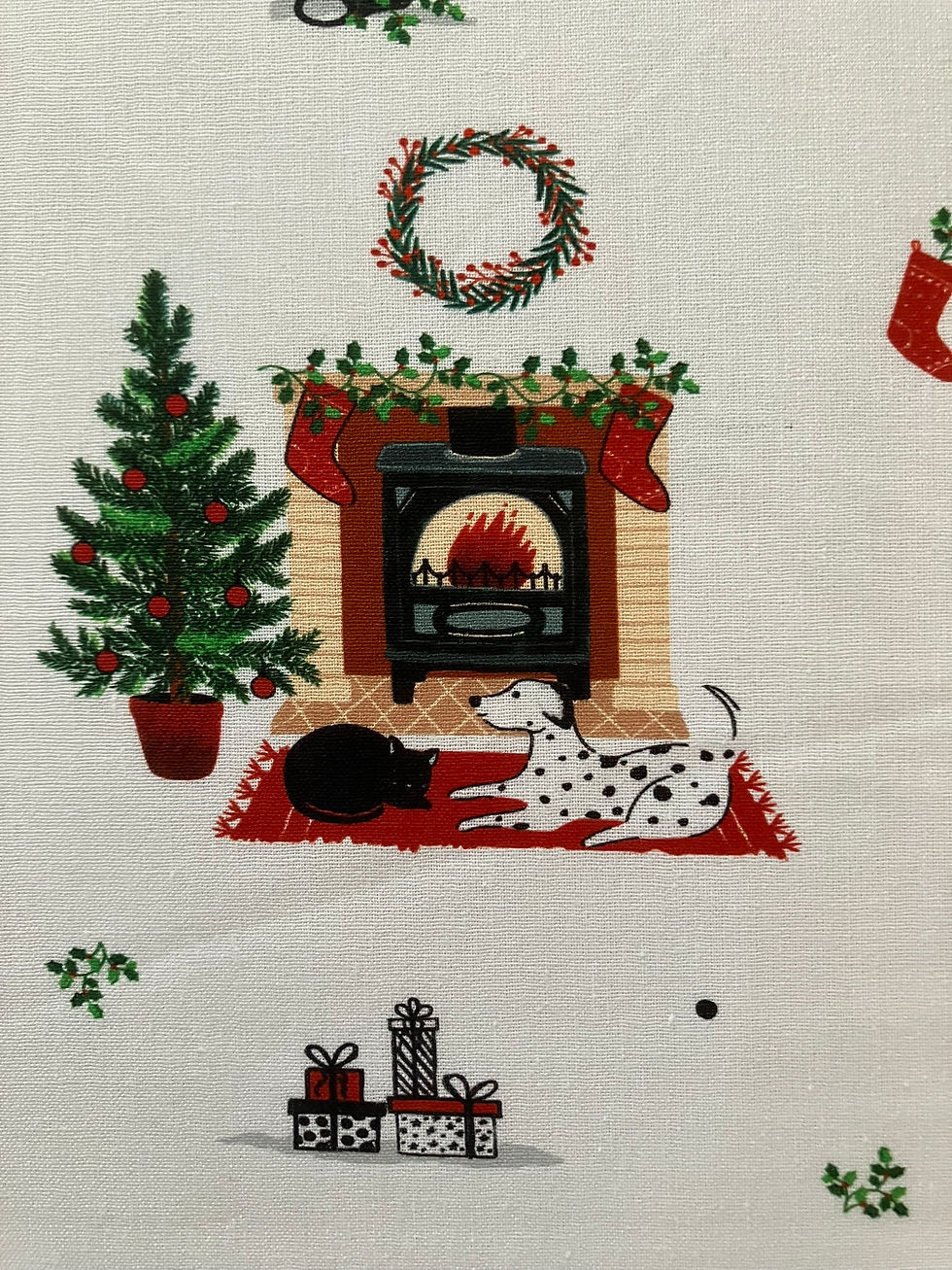 Thumbnail: Dalmatian Dog Christmas fabric , features dogs and cats lying by a Christmas fireplace. Up close view.