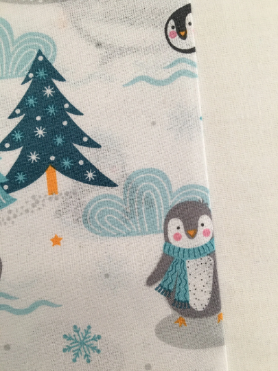 Thumbnail: Penguin Christmas fabric, penguins playing around in the snow, on a white background. Showing fabric colour against white