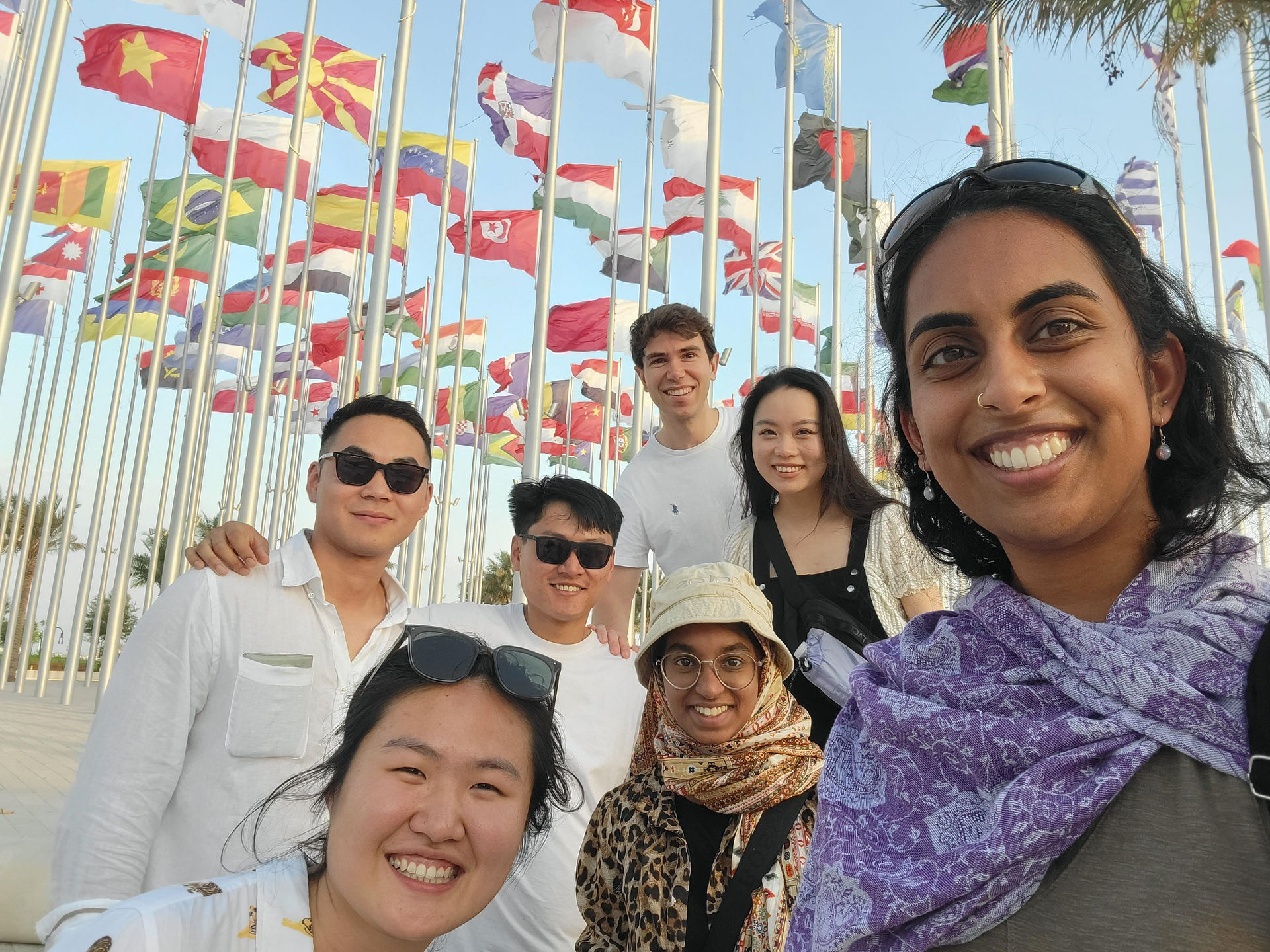 A group of people in front of flags of every country
