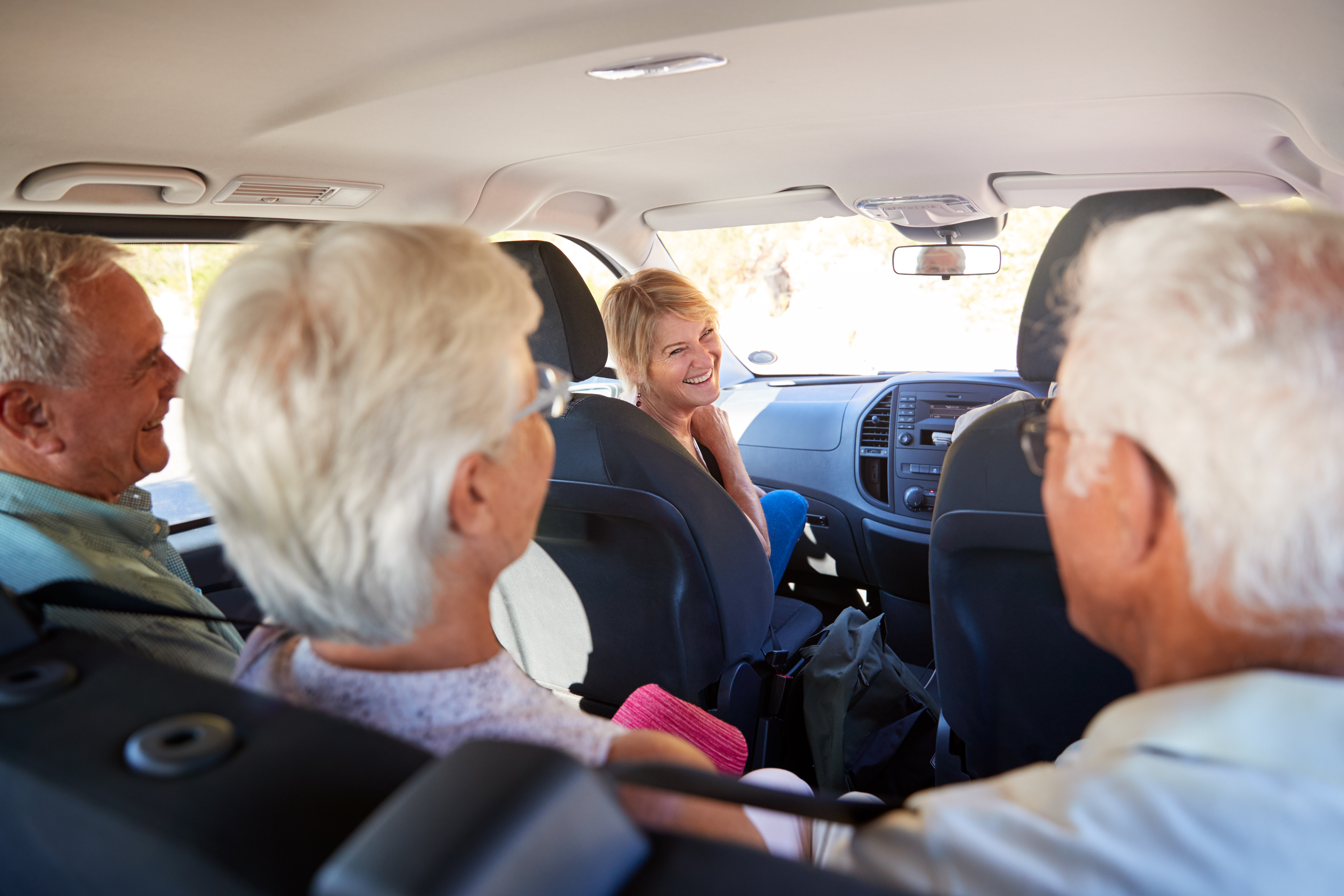 people sitting and talking inside of a van