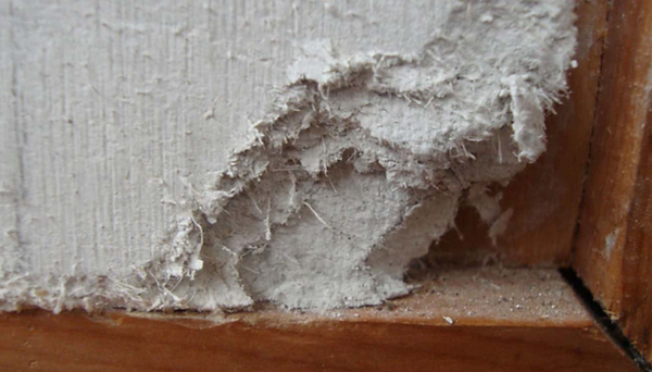 Asbestos wall panel is broken off