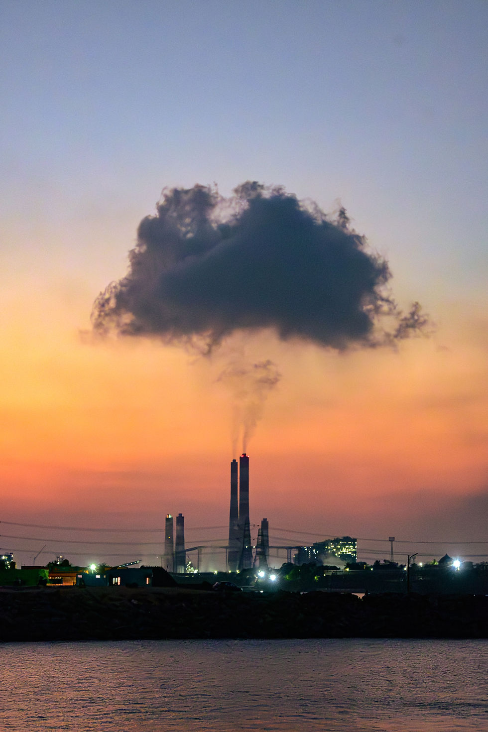 Industrial power plant chimneys at sunset with dramatic smoke clouds by industrial photographer Arun Siddharth