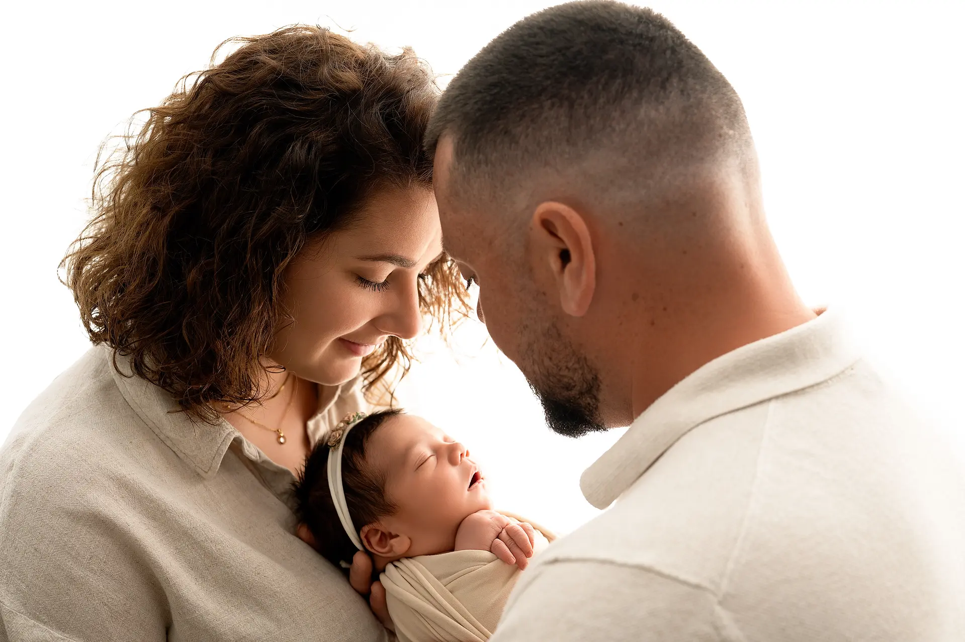 Parents admirant leur nouveau-né dans un moment de tendresse lors d'une séance photo naissance en studio à Dreux