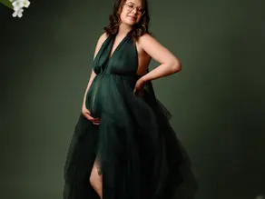 Future maman en robe verte lors d’une séance photo grossesse en studio à Dreux