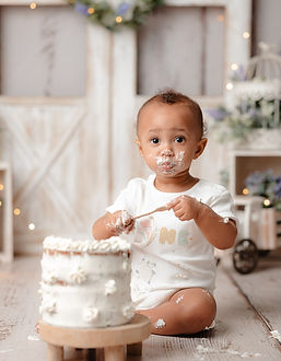 Bébé dégustant son gâteau d'anniversaire blanc lors de sa séance smash cake