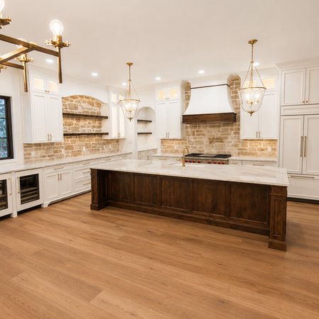 Luxury custom kitchen with oversized marble waterfall island, white shaker cabinets, stone backsplash, designer pendant lighting, professional-grade appliances, and warm hardwood floors in a modern farmhouse home.
