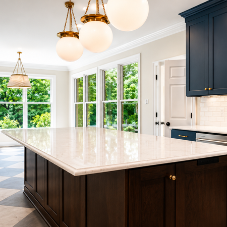 Custom blue kitchen cabinetry with integrated refrigerator panels, brass hardware, quartz countertops, and luxury modern kitchen storage design.