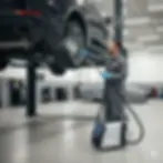 Mantenimiento y limpieza de chasis de vehículos en elevador automotriz. Un técnico inspecciona y prepara la zona del neumático y el bajo del coche para detailing o servicio profesional con equipo especializado.