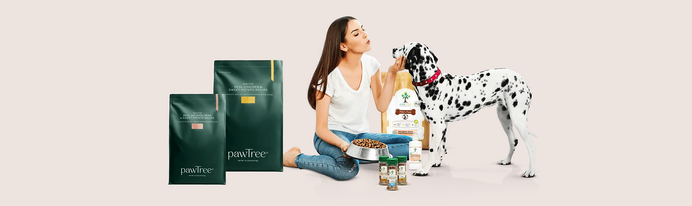 a lady petting a dog with bags of dog food in the background 