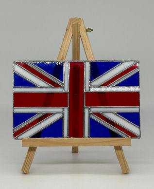 Handmade Union Jack stained glass panel in rippled red white and blue glass displayed on a wooden easel