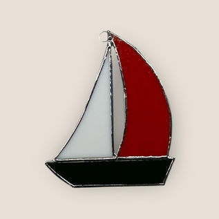 Handmade stained glass sailboat suncatcher with red and white sails and dark hull
