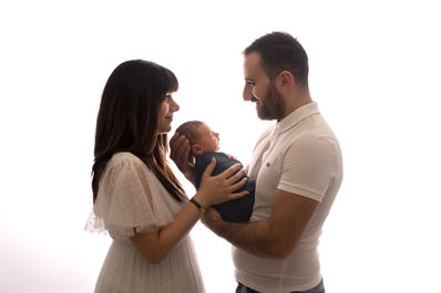Séance photo d'un couple avec leur bébé sur fond blanc