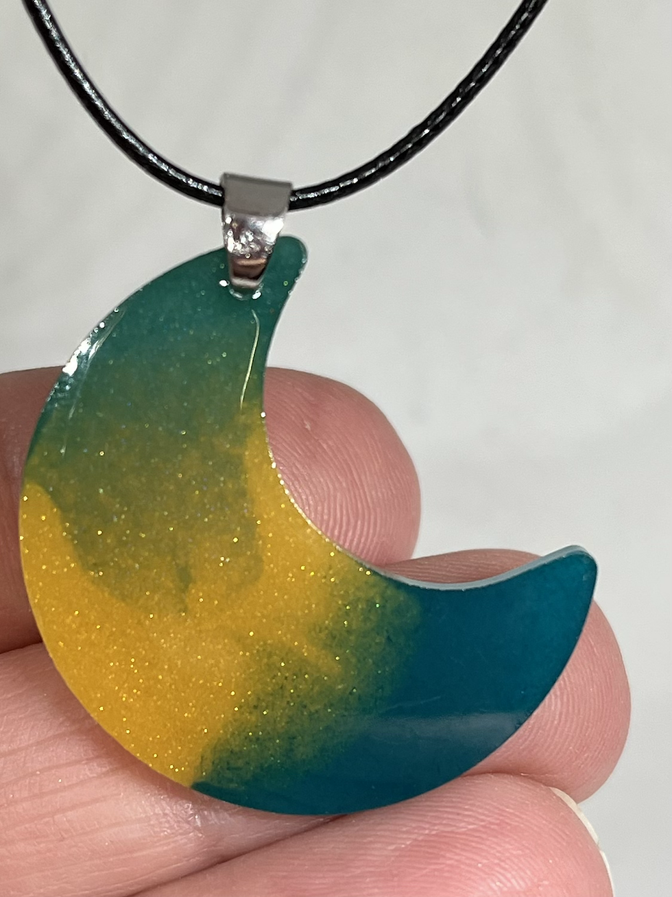 Thumbnail: Maan met groen, blauw en goud