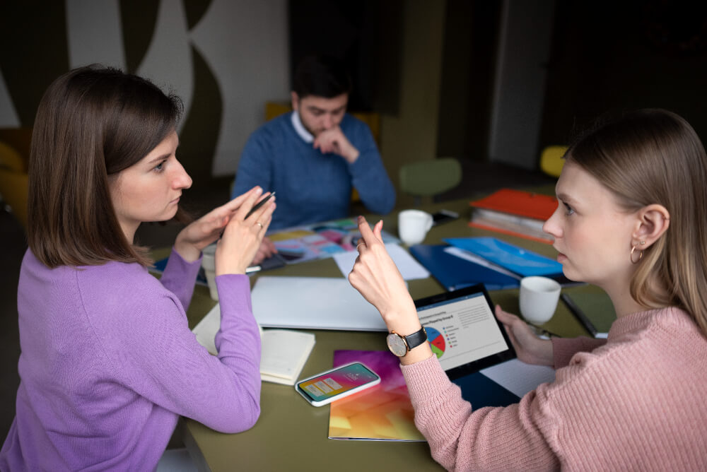 três pessoas em discussão em grupo