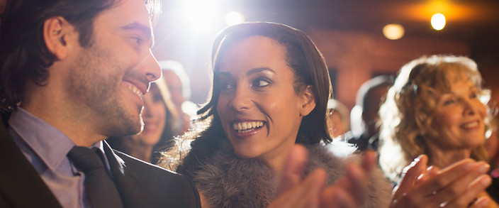 Close up of couple clapping in theater