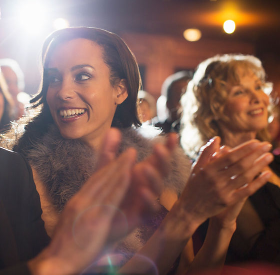 Close up of couple clapping in theater