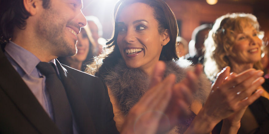 Close up of couple clapping in theater