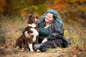 Australian Shepherd Hündin red bi blaue Augen im Wald im Herbst Portrait mit Mädchen Frau blaue Haare im Sitzen kuscheln Tierfotografie Hundefotografie 