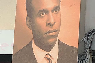 A sepia tone image of the psychologist, theorist and activist Frantz Fanon, from a Martinique park
